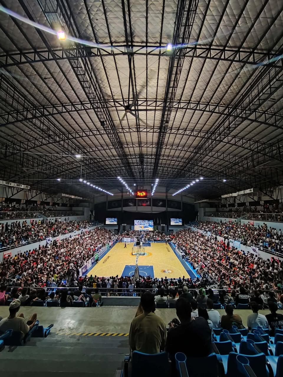 Packed arena crowd watching a basketball game