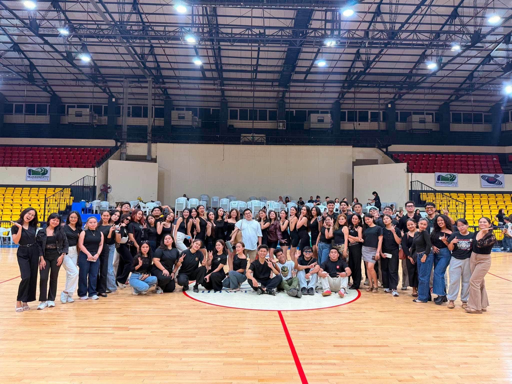 Full production crew group photo inside a sports arena